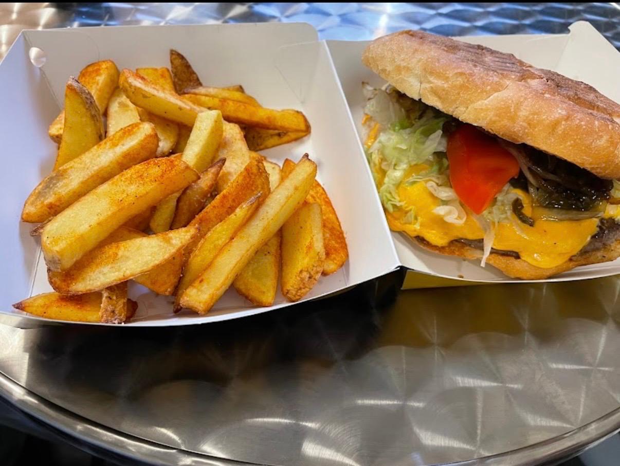 Burger mit Käse und goldbraunen Pommes
